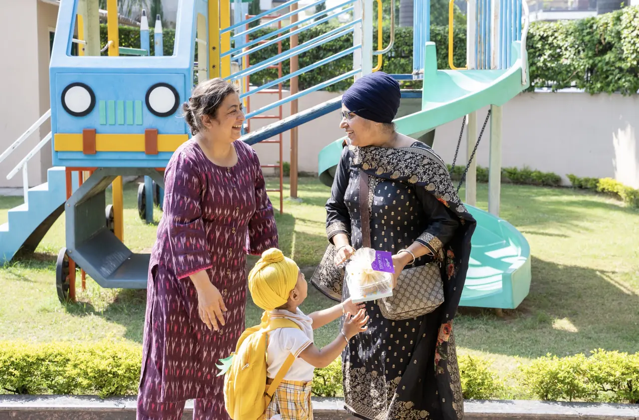 Parents and a teacher talking with a child at school