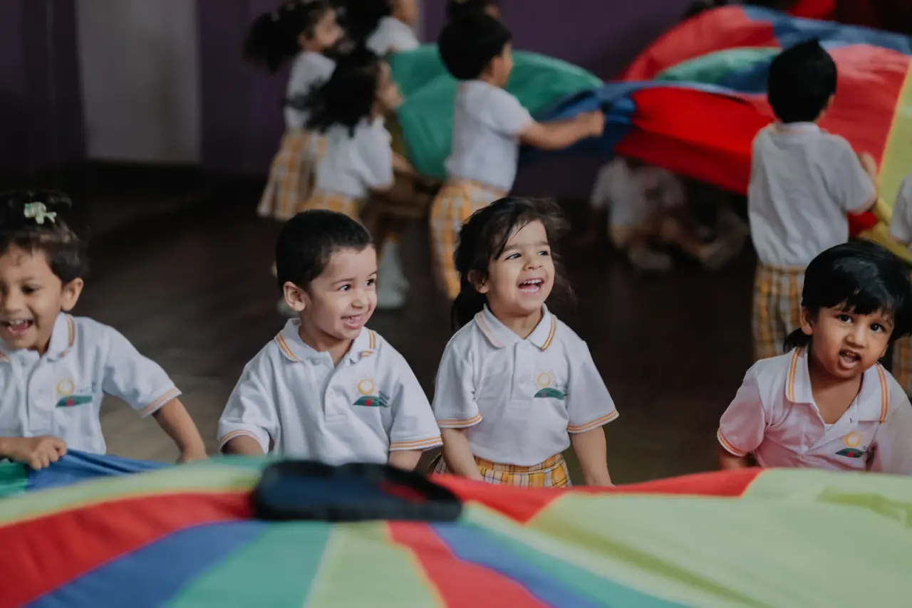 Children playing under a parachute in Jolly World