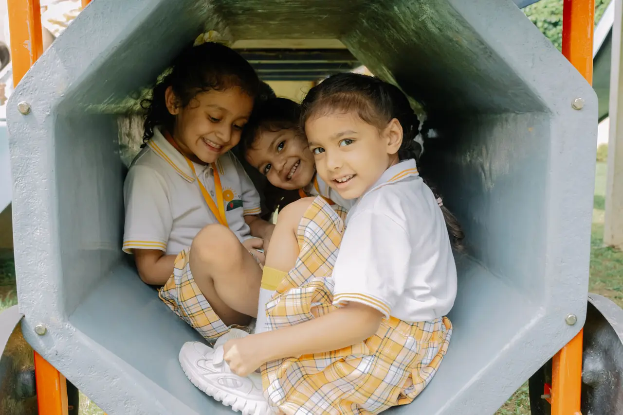 Three friends inside the play tunnel