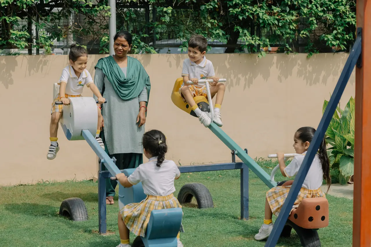 Children on the see-saws in the play pen